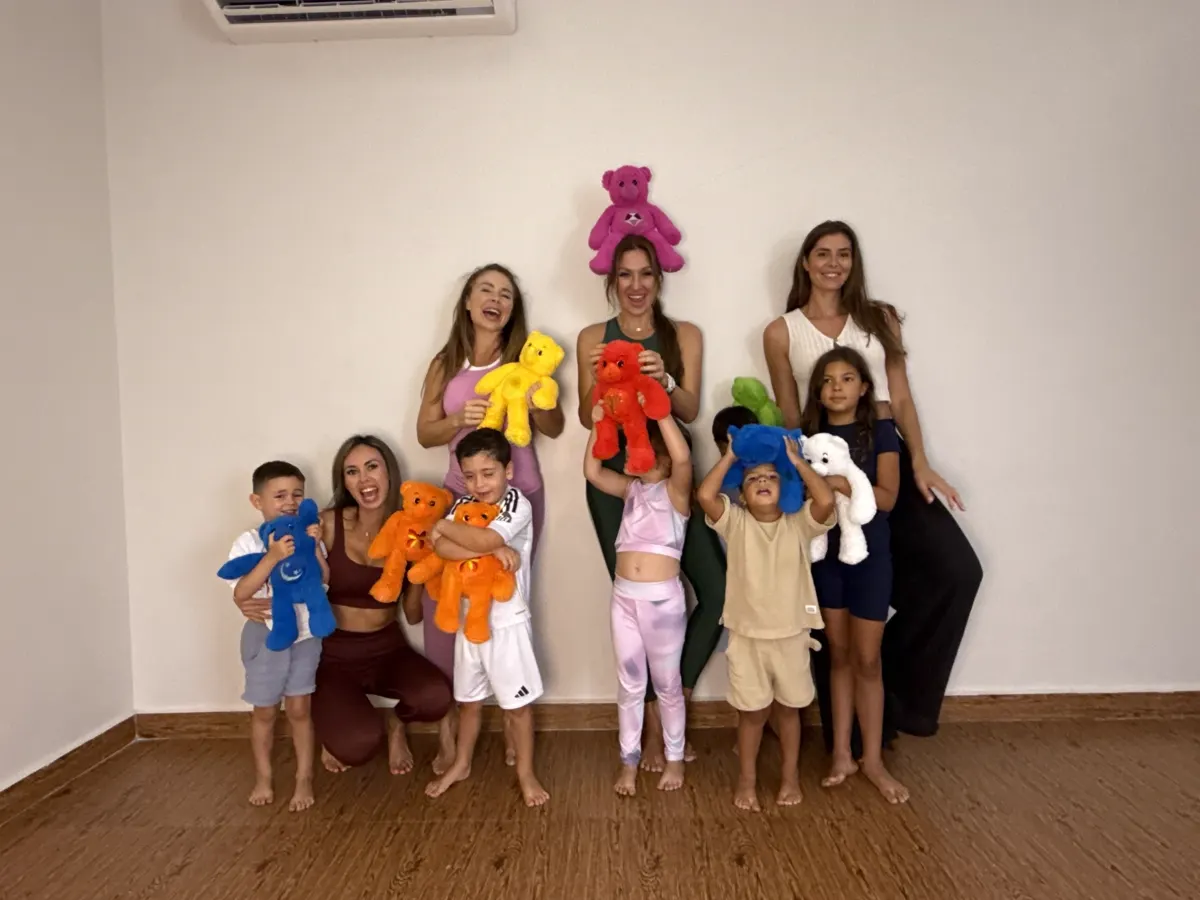 Instructors and children posing with colorful YogaBears plush characters