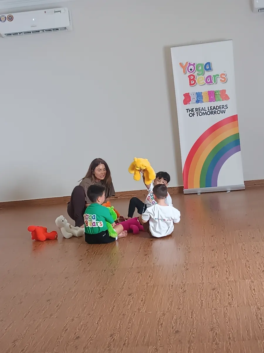 Children and an instructor in a YogaBears studio session with branded banner