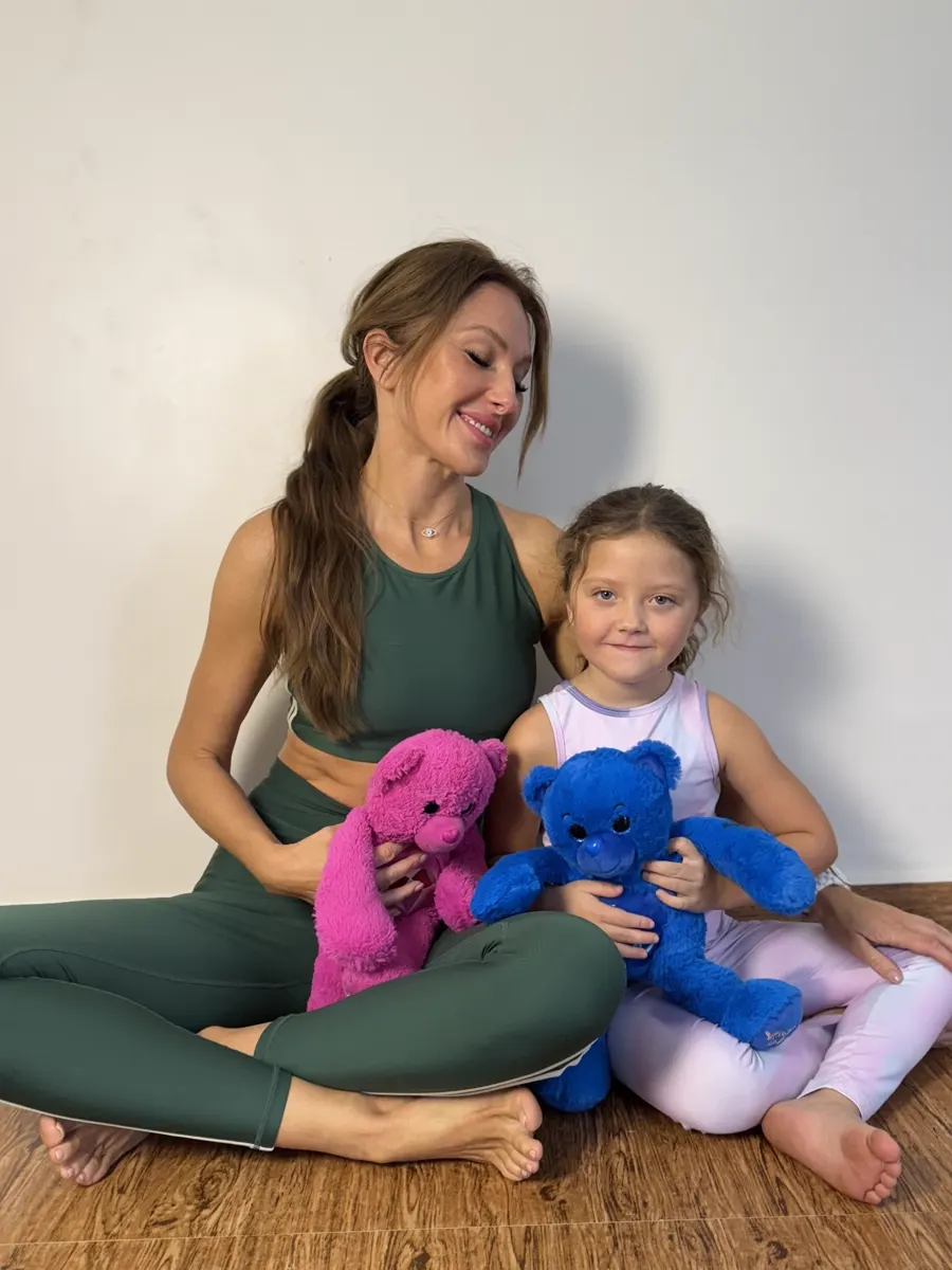 Mother and daughter holding pink and blue YogaBears plush characters