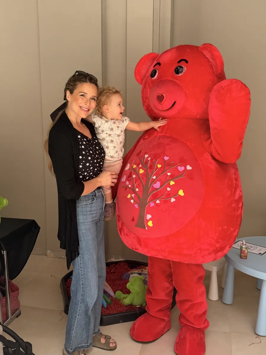 Mother and toddler meeting the red YogaBears mascot character