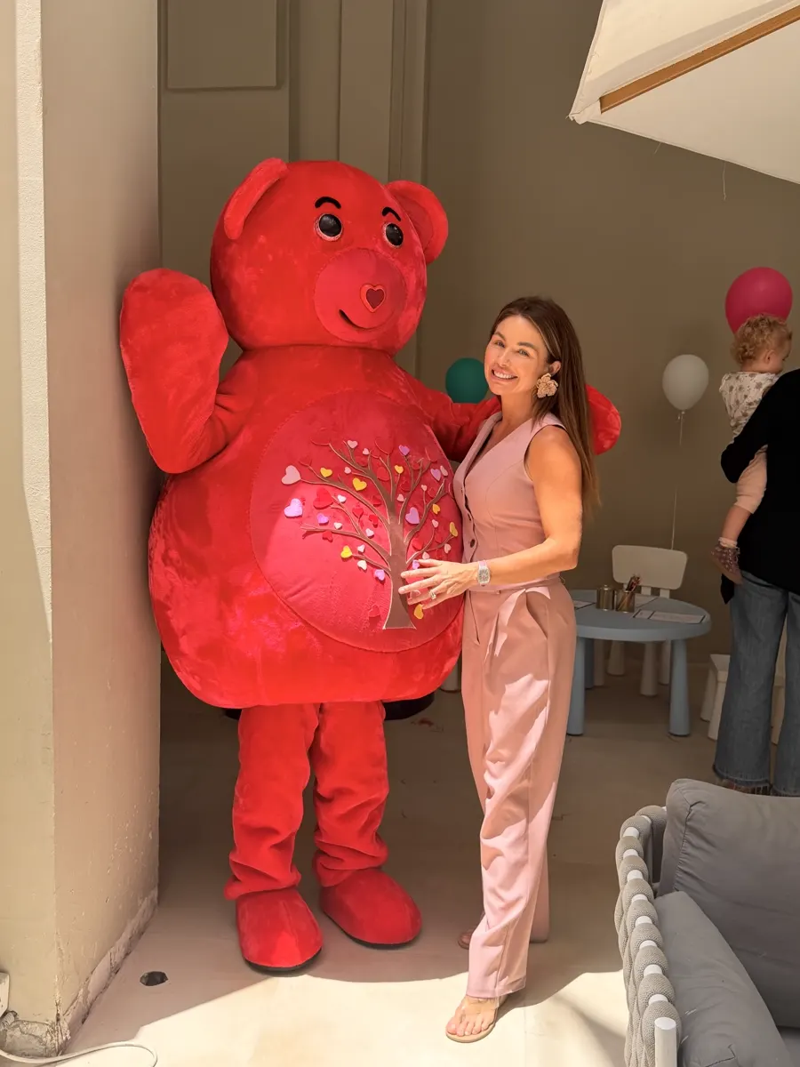 Party guest posing with the red YogaBears mascot character